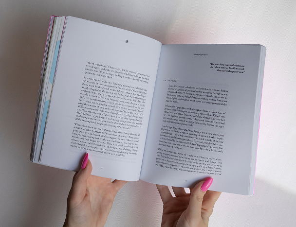 Book being held open to display a page layout design from the Designer Interviews project